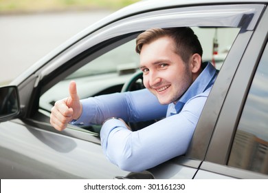 Man doing thumbs up in car Foto Stock