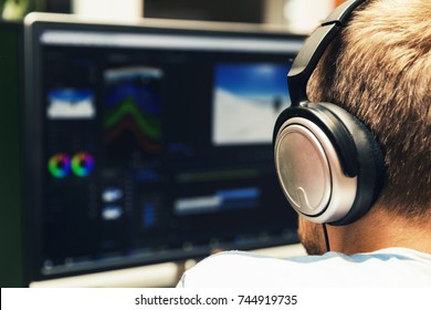 Man Doing Video Editing On Computer With Headphones On