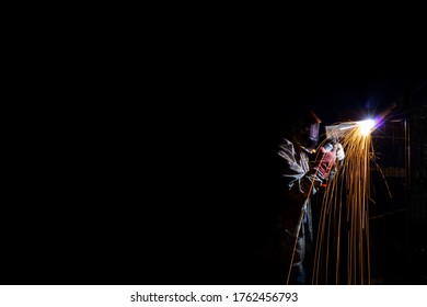 man doing welding work, by an arc manual apparatus, in the dark