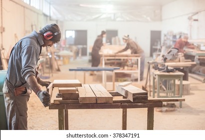 Man doing woodwork in carpentry. Carpenter work on wood plank in workshop - Powered by Shutterstock