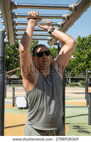 Man doing a workout on monkey bars in an outdoor gym on a sunny day