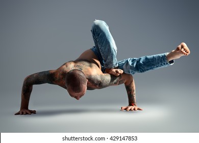 A man doing yoga exercises. Studio shot over gray background. 