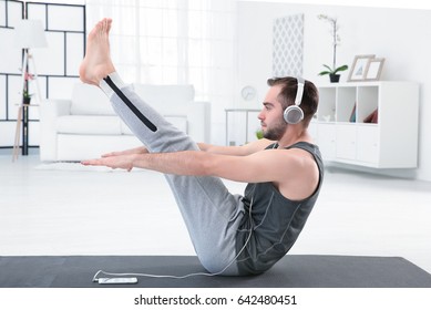 Man Doing Yoga And Listening To The Music At Home