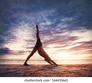 Man doing Yoga on the beach near the ocean in India - Powered by Shutterstock