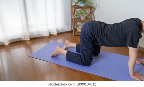 A Man Doing Yoga In The Room.Cat And Cow Poses.