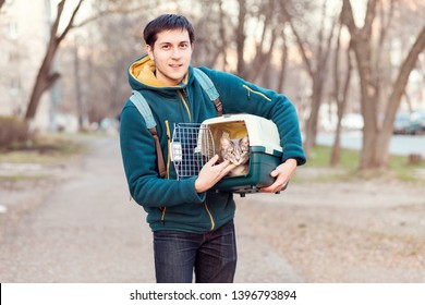 Man With Domestic Cat In A Pet Carrier Traveling On The Street