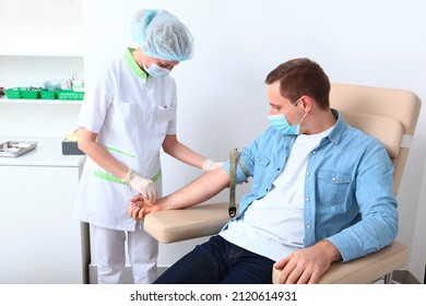 A man donates blood in a medical laboratory. Tourniquet on the patient's arm. A general blood test. Nurse and patient. The concept of healthcare.Copy space.