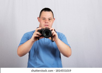 A Man With Down Syndrome With Camera On White Background