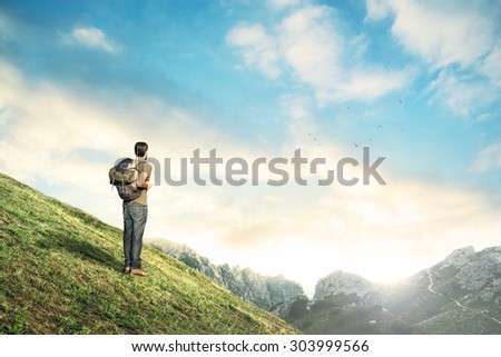 Man downhill observing mountain landscape at sunset