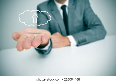 A Man With A Drawing Of A Cloud With An Arrow Inside, Depicting The Concept Of Upload To The Cloud Storage