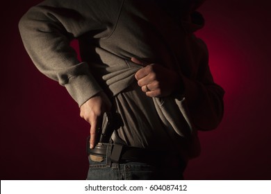 A Man Drawing A Conceal Carry Pistol From An Inside The Waistband Holster IWB.