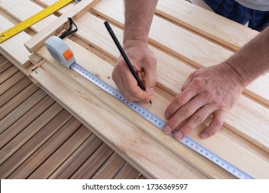 Man drawing line wooden shelf   holding construction ruler  Carpenter working at balcony and wood  House improving  DIY   home decoration during quarantine concept