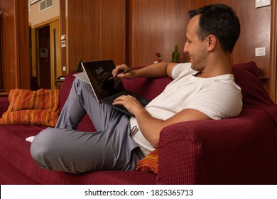 Man Drawing In Mock Up Tablet Screen Laying On The Sofa At Home