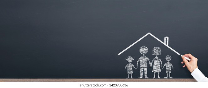 Man Is Drawing Roof On The Family On Chalkboard. Home Ownership Concept