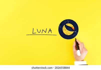 man draws a terra icon next to the inscription luna. blockchain and cryptocurrency concept