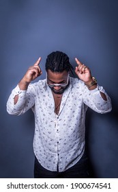 Man with dreadlocks pointing to the sky. Studio photography.