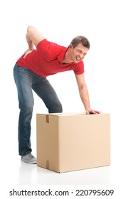 Man Dressed In Casual Clothing Hurt His Back Lifting Large Box. Young Man Suffering From Back Pain Isolated On White Background