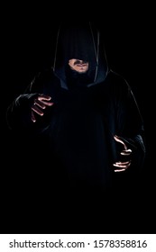 Man Dressed In A Dark Robe Looking Like A Cult Leader On A Smoky Or Foggy Background.  He Looks Like A Creepy Evil Villain