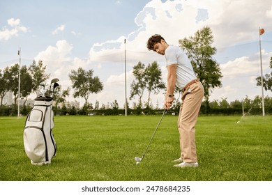 A man dressed in elegant clothes is hitting a golf ball on a lush green field at a golf club. - Powered by Shutterstock