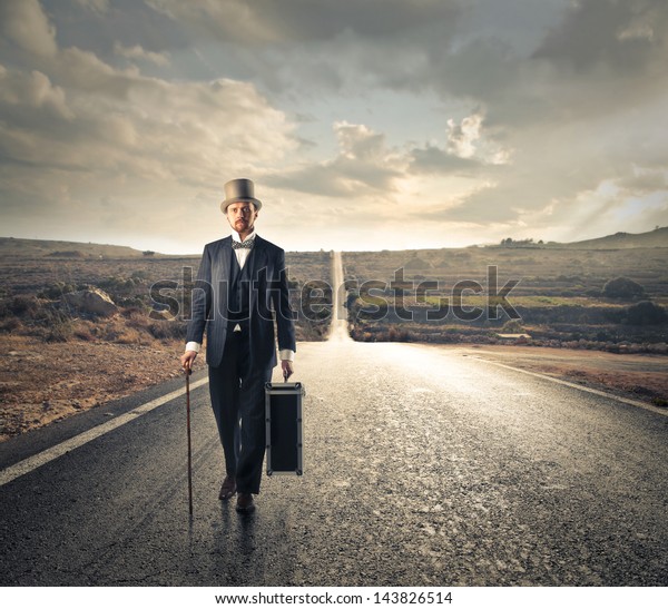 man dressed in\
old clothes walking on the\
road