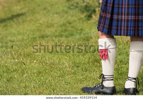 Man dressed in traditional Tartan Kilt an example\
of Scotlands national\
costume