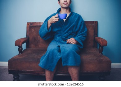 Man In Dressing Gown Drinking Coffee On Vintage Sofa