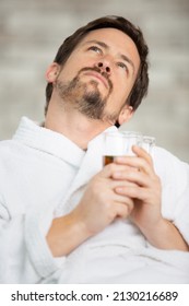 Man In Dressing Gown Drinking Tea On Sofa