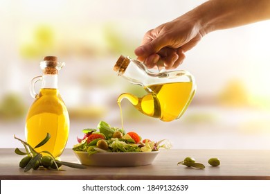 Man Dressing A Mediterranean Salad Of Fresh Vegetables On A Wooden Table In A Kitchen. Front View. Horizontal Compositon.