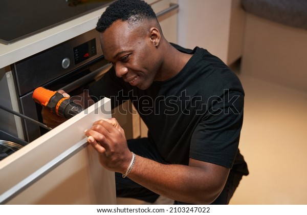 Man with\
drill working on attaching handle to\
drawer