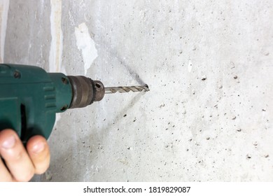 Man Is Drilling Hole In The Concrete Wall. Repair Works. Maintenance In The Apartment.