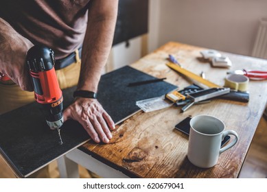 Man drilling laminate with power drill on the table - Powered by Shutterstock