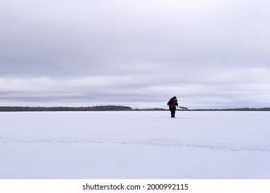 Man Drills Holes For Ice Fishing With An Electric Auger. Selective Focus