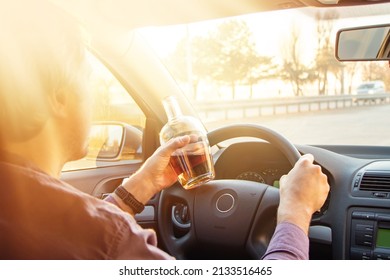 Man Drinking Alcohol While Driving In His Car On Sunset.