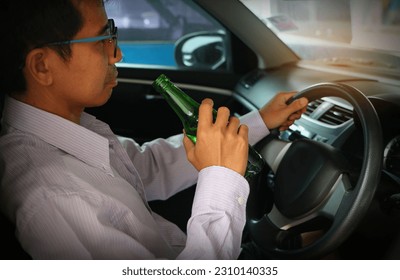 Man drinking alcohol while driving a car