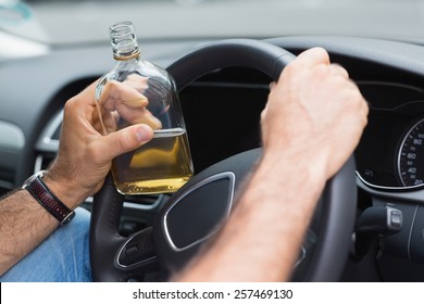 Man drinking alcohol while driving in his car