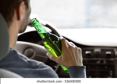 Man Drinking Beer While Driving Car, Closeup. Don't Drink And Drive Concept