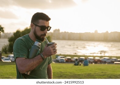 Man drinking chimarrao, mate (an infusion of yerba mate with hot water) at sunset in uruguay