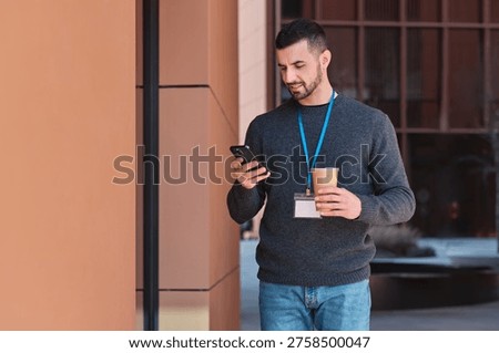 Man drinking coffee and checking phone during outdoor business conference