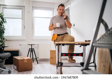 a man drinking coffee and making a phone call during a renovation break - Powered by Shutterstock