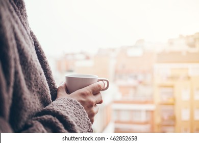 Man Is Drinking Coffee On A Balcony. Close Up Of Hands With White Cup Of Coffee. Early Morning Routine