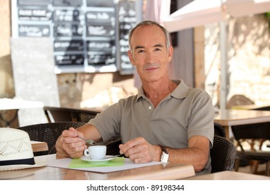 Man Drinking Coffee Outside A Cafe