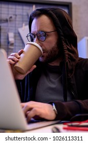 man drinking coffee and using laptop