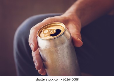 Man Drinking A Cold Beer After Work In The Evening. Hand Holding A Aluminum Can.