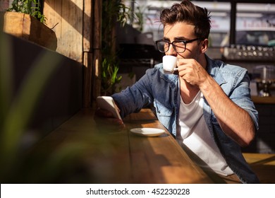 Man Drinking A Cup Of Coffee In The Cafe