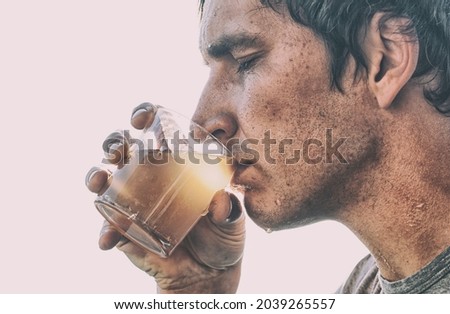 Man is drinking dirty water from the glass cup
