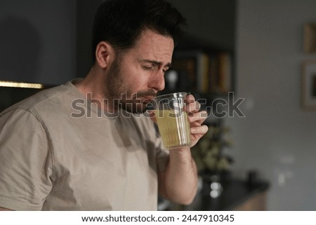 Man drinking electrolytes in the kitchen