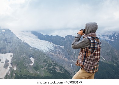 Man Drinking Hot Coffee In Thermos Mug And Looking Into The Mountains In Snow, Winter Hike, Cold Season