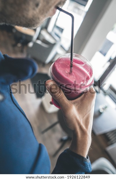 Man drinking juice at\
café