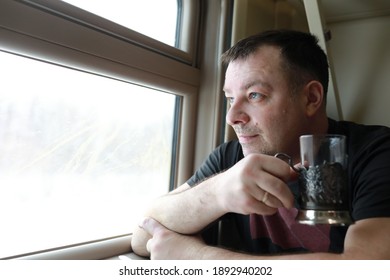 Man Drinking Tea In Train Next To Window