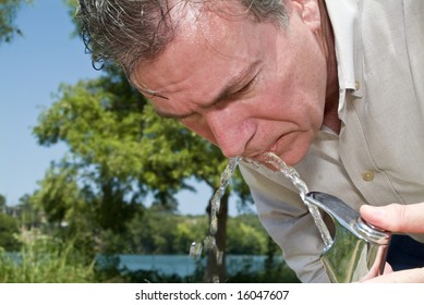 A Man Drinking Water From A Park Water Fountain No A Very Hot Summer Day.